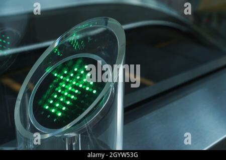 Grüner Pfeil mit LED-Anzeigen, die die Bewegungsrichtung der Rolltreppe am Flughafen anzeigen Stockfoto