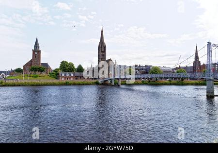 Die Hängebrücke der Greig Street überquert den Fluss Ness in Inverness mit der Free North Church. Inverness, Schottland - Vereinigtes Königreich - 18. Juli 2021 Stockfoto