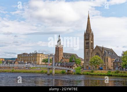 Die Hängebrücke der Greig Street überquert den Fluss Ness in Inverness mit der Free North Church. Inverness, Schottland - Vereinigtes Königreich - 18. Juli 2021 Stockfoto