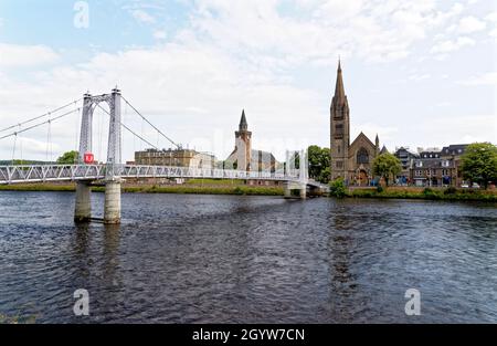 Die Hängebrücke der Greig Street überquert den Fluss Ness in Inverness mit der Free North Church. Inverness, Schottland - Vereinigtes Königreich - 18. Juli 2021 Stockfoto