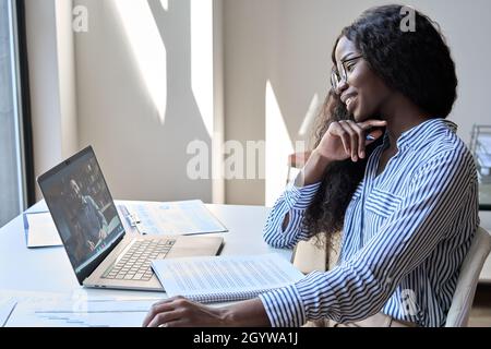 Glückliche schwarze Geschäftsfrau mit virtuellen Treffen mit indischen Mann Remote-Arbeit. Stockfoto