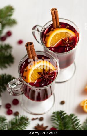 Glühwein in Gläsern auf weißem Hintergrund in der Nähe des Weihnachtsbaums Stockfoto