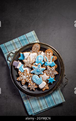 Dekorierte blaue und weiße EisLebkuchen Weihnachtsplätzchen auf Platte. Grauer Hintergrund. Draufsicht mit Copyspace Stockfoto