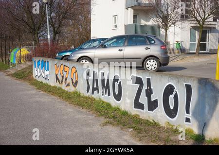 POZNAN, POLEN - 01. Apr 2016: Textzeichnung des Fußballvereins Lech auf Polnisch an einem Steinzaun durch geparkte Autos und Wohngebäude Stockfoto