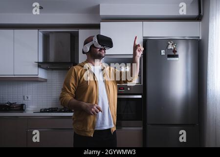 Der junge Mann, der aus der Küche in die Welt der Metaverse kam. Stockfoto