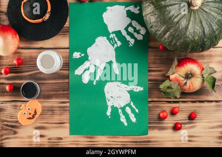 Schritt-für-Schritt Halloween Tutorial Geister Kinder Handprint. Schritt 7: Drehen Sie ein Blatt Papier mit weißen Handflächen um. Draufsicht Stockfoto