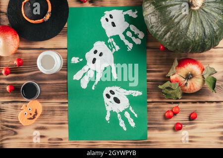 Schritt-für-Schritt Halloween Tutorial Geister Kinder Handprint. Schritt 9: Fertig ist die Zeichnung von Geistern, die mit Kinderhanddrucken angefertigt wurden. Draufsicht Stockfoto