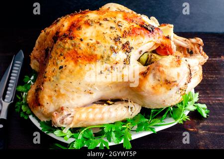 Ganze geröstete Pute auf einer Platte: Nahaufnahme einer ganzen pute auf einer Platte, garniert mit Petersilie Stockfoto