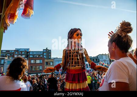 Zwei Frauen sehen sich den kleinen Amal an.Eine riesige Marionette erregt derzeit in ganz Europa die Aufmerksamkeit auf die Not junger Flüchtlinge, die aus Syrien geflohen sind. Little Amal ist ein neun Jahre altes Mädchen aus Syrien und über 11 Meter groß. Sie ist fast 8,000 km von der syrisch-türkischen Grenze entfernt auf der Suche nach ihrer Mutter und wird im November in Manchester enden. An diesem Wochenende wurde Amal, was auf Arabisch „Hoffnung“ bedeutet, von Kindern, Musikern und anderen Giganten in dem für seine kulturelle Vielfalt bekannten Stadtteil Borgerhout herzlich begrüßt. (Foto von Ana Fernandez/SOPA Images/Sipa USA) Stockfoto