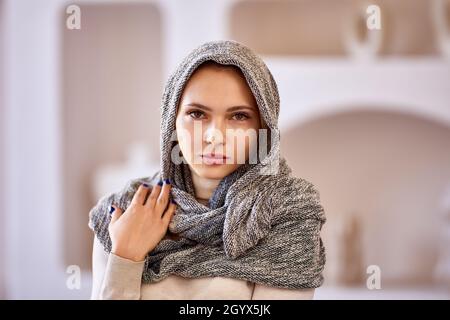 Porträt einer jungen europäischen Frau mit Schal auf dem Kopf. Stockfoto