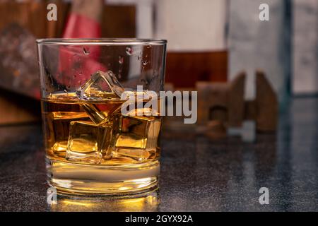 Glas Bourbon Whiskey, auf den Felsen, mit Eis, vor Vintage-Werkzeugen Stockfoto