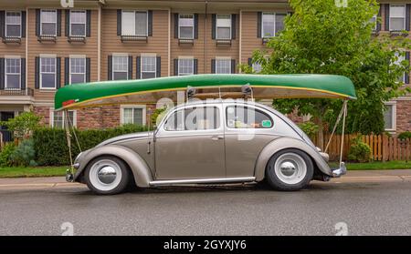 Klassischer Volkswagen Beetle mit Bootladung oben geparkt in einer Straße. Bereit für die Reise. Langley, BC, Kanada - September 8,2021. Blick auf die Straße, Reisen Stockfoto