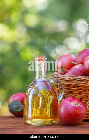 apfelessig oder Apfelwein in Glasflasche im Freien Stockfoto