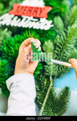 Ein Mädchen zeichnet einen Weihnachtsbaum und bereitet sich auf das neue Jahr 2022 vor. Frohe Weihnachten und ein glückliches neues Jahr Konzept Stockfoto