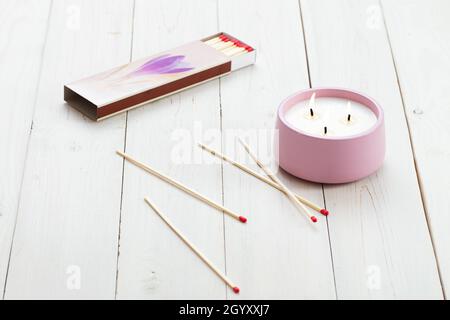 Brennende Kerzen und verstreute Streichhölzer auf einem Holztisch. Inneneinrichtung. Stockfoto