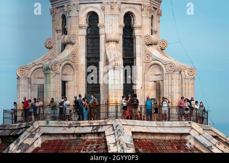 Die Besucher spazieren auf den Kuppelterrassen der Kathedrale, die Brunelleschi während der Renaissance in Florenz entworfen hat. Foto vom Glockenturm. Stockfoto