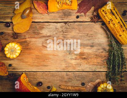 Thanksgiving Herbsttisch Hintergrund. Speiseangebot mit saisonalen Herbstspezialitäten zum Thanksgiving Day. Kürbis, Gemüse und Dekor auf einem Holztisch. Speicherplatz kopieren. Hochwertige Fotos Stockfoto