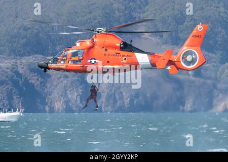 Oktober 2021; San Francisco, Kalifornien, USA; ein Taucher der US-Küstenwache demonstriert während der 40. jährlichen San Francisco Fleet Week eine Wasserrettung mit dem Eurocopter MH-65 Dolphin Helikopter. (Stan Szeto/Image of Sport) Stockfoto