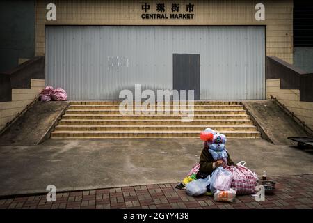 Hongkongs berühmte Bag Lady vor dem hinteren Eingang des Central Market (heute nicht mehr verfügbar), Central, Hong Kong Island, im Jahr 2009 Stockfoto