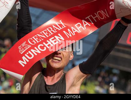 München, Deutschland. Oktober 2021. Alexander Hirschhäuser überquert beim Münchner Marathon 2021 als erster die Ziellinie im Olympiastadion. Hirschhäuser lief in 2:18:38 Stunden bei kalten Temperaturen knapp über dem Gefrierpunkt zum Titel. Kredit: Peter Kneffel/dpa/Alamy Live Nachrichten Stockfoto