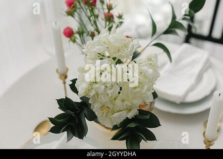 Elegante klassische Tischunterlage mit weißem Geschirr und goldfarbenem Besteck Stockfoto
