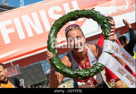 München, Deutschland. Oktober 2021. Corinna Harrer hält einen Lorbeerkranz und jubelt nach ihrem Sieg beim Münchner Marathon 2021 im Olympiastadion. Der ehemalige Mittelstreckenspezialist lief in 2:43:11 Stunden die Strecke zwischen dem Olympiastadion und dem Englischen Garten. Kredit: Peter Kneffel/dpa/Alamy Live Nachrichten Stockfoto