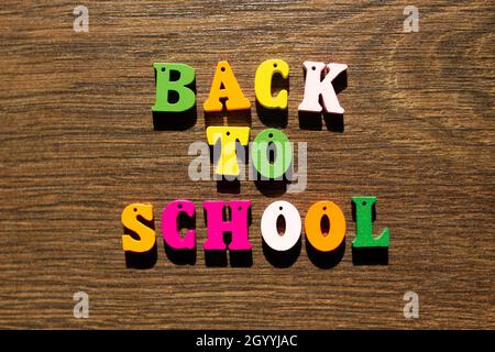 Inschrift der Worte des Slogans Back to School in mehrfarbigen Buchstaben mit Schatten auf einem schönen Hintergrund. Bunte Buchstaben des Alphabets Stockfoto