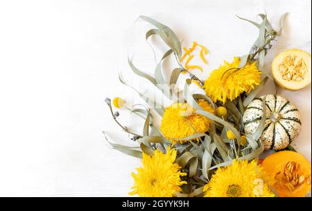 Festliches Herbstdekor aus Kürbissen und Blumen auf weißem Hintergrund, Kopierfläche. Konzept des Erntedankfestes oder Halloween. Stockfoto