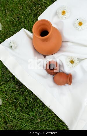 Tontöpfe auf einer weißen Tischdecke auf dem Gras. Draufsicht Stockfoto