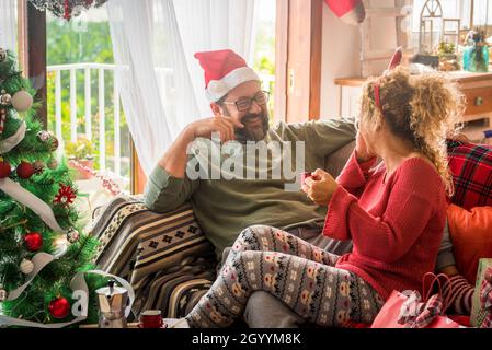 Mann, der sich mit seiner Frau während der Weihnachtsfeier zu Hause beim Kaffeetrinken amüsieren kann. Kaukasisches Paar beim Frühstück am Vorabend von Weihnachten. Paar i Stockfoto