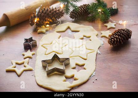 Weihnachtskekse mit verschiedenen Accessoires auf einem Holztisch zubereiten, Weihnachten und Neujahr vorbereiten Stockfoto