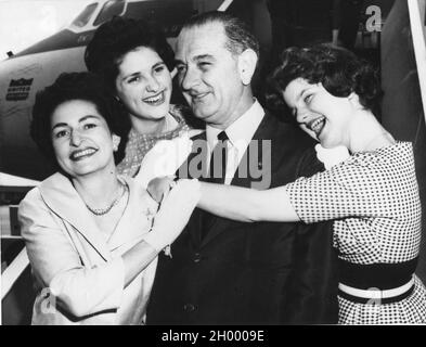 Senator Lyndon B. Johnson wird von seiner Frau Lady Bird (links) und ihren Töchtern Lynda (links) und Lucy (rechts) umarmt. Die Johnsons waren auf dem Weg zur Demokratischen Konvention in Los Angeles. 7-7-60. Stockfoto