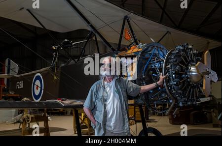 Senior man bei der Replik WWI Sopwith 1 1/2 Strutter Flugzeug Doppeldecker im Bau von Aviation Preservation Society of Scotland, East Lothian, UK Stockfoto