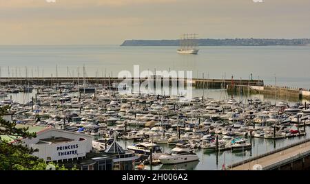 Das viereckige Segelschiff Golden Horizon vor Anker in Tor Bay, South Devon, dem Hafen von Torquay und dem Theater Princess. Stockfoto