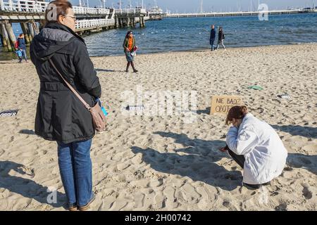 Sopot, Polen. Oktober 2021. Demonstranten vor dem Transparent "sei nicht gleichgültig" sind am 10. Oktober in Sopot, Polen, zu sehen.2021 Menschen protestieren unter dem Motto: Nimm die Kinder nicht in den Wald mit. Sie protestieren gegen die Politik der polnischen Regierung, Flüchtlinge aus dem Irak, Afghanistan und anderen Ländern, die mit kleinen Kindern aus Belarus in den Wald an der Grenze zu Belarus kommen, zu drängen. Die polnische Regierung verweigert ihnen internationalen Schutz und transportiert sie illegal in den Wald, um sie ins Ausland zu drängen. Quelle: Vadim Pacajev/Alamy Live News Stockfoto