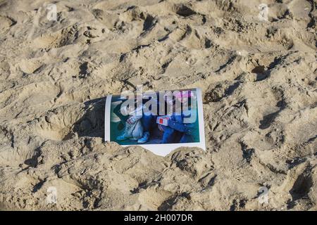 Sopot, Polen. Oktober 2021. Ein Bild von Flüchtlingen im Sand ist am 10. Oktober 2021 in Sopot, Polen zu sehen.Menschen protestieren unter dem Motto: Bringt die Kinder nicht in den Wald. Sie protestieren gegen die Politik der polnischen Regierung, Flüchtlinge aus dem Irak, Afghanistan und anderen Ländern, die mit kleinen Kindern aus Belarus in den Wald an der Grenze zu Belarus kommen, zu drängen. Die polnische Regierung verweigert ihnen internationalen Schutz und transportiert sie illegal in den Wald, um sie ins Ausland zu drängen. Quelle: Vadim Pacajev/Alamy Live News Stockfoto