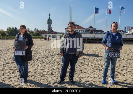 Sopot, Polen 10. Oktober 2021 Demonstranten, die das als Stacheldraht in Form von weißrussischer Stickerei stilisierte „Grenzbanner“ halten, sind am 10. Oktober 2021 in Sopot, Polen, zu sehen.Menschen protestieren unter dem Motto: Bringen Sie die Kinder nicht in den Wald. Sie protestieren gegen die Politik der polnischen Regierung, Flüchtlinge aus dem Irak, Afghanistan und anderen Ländern, die mit kleinen Kindern aus Belarus in den Wald an der Grenze zu Belarus kommen, zu drängen. Die polnische Regierung verweigert ihnen internationalen Schutz und transportiert sie illegal in den Wald, um sie ins Ausland zu drängen. Quelle: Vadim Pacajev/Alamy Stockfoto