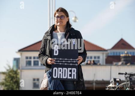 Sopot, Polen 10. Oktober 2021 in Sopot, Polen, wird am 10. Oktober 2021 ein Protestler mit dem als Stacheldraht stilisierten „Grenzbanner“ in Form einer weißrussischen Stickerei gesehen, bei dem die Menschen unter dem Motto protestieren: Bringen Sie die Kinder nicht in den Wald. Sie protestieren gegen die Politik der polnischen Regierung, Flüchtlinge aus dem Irak, Afghanistan und anderen Ländern, die mit kleinen Kindern aus Belarus in den Wald an der Grenze zu Belarus kommen, zu drängen. Die polnische Regierung verweigert ihnen internationalen Schutz und transportiert sie illegal in den Wald, um sie ins Ausland zu drängen. Quelle: Vadim Pacajev/Alamy L. Stockfoto