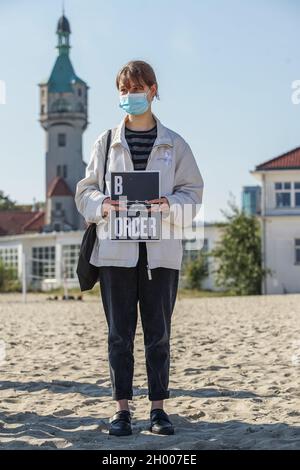 Sopot, Polen 10. Oktober 2021 in Sopot, Polen, wird am 10. Oktober 2021 ein Protestler mit dem als Stacheldraht stilisierten „Grenzbanner“ in Form einer weißrussischen Stickerei gesehen, bei dem die Menschen unter dem Motto protestieren: Bringen Sie die Kinder nicht in den Wald. Sie protestieren gegen die Politik der polnischen Regierung, Flüchtlinge aus dem Irak, Afghanistan und anderen Ländern, die mit kleinen Kindern aus Belarus in den Wald an der Grenze zu Belarus kommen, zu drängen. Die polnische Regierung verweigert ihnen internationalen Schutz und transportiert sie illegal in den Wald, um sie ins Ausland zu drängen. Quelle: Vadim Pacajev/Alamy L. Stockfoto