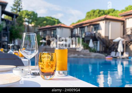 Tisch-Einstellung. Leere Gläser auf dem Hintergrund des Pools und der Villen des Hotels. Service der Gäste im Hotel im Sommer im Urlaub, zurück Stockfoto