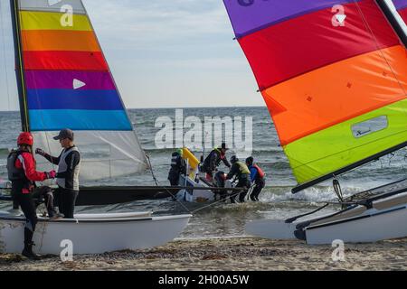 Oslonino, Polen, 3. Oktober. 2021 Katamaransegler an der Küste der Ostsee (Puck Bay) werden am 3. Oktober in Mechelinki, Polen, gesehen 2021 Menschen genießen sonniges, warmes Herbstwetter beim Spazierengehen an den Ostseestränden und treiben Wassersport Credit: Vadim Pacajev/Alamy Live News Stockfoto