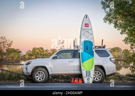 Fort Collins, CO, USA - 4. Oktober 2021: Toyota 4Runner SUV (2016 Trail Modell) mit aufblasbarem Touring Stand Up Paddleboard von Red in der Dämmerung nach p Stockfoto