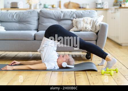 Positive reife Dame, die Kraftübungen macht, in guter Form hervorragende Fitness im Ruhestand zu halten Stockfoto