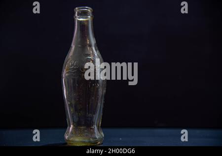 Santa Maria / RS / Brasilien. 03/24/2021. Gedenkflasche und leere Sodaflasche auf schwarzem Hintergrund. Kühlen von Ampullen. Kohlensäurehaltige Getränke Alte Coca-Cola-Kontra Stockfoto