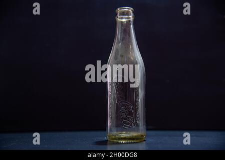 Santa Maria / RS / Brasilien. 03/24/2021. Gedenkflasche und leere Sodaflasche auf schwarzem Hintergrund. Kühlen von Ampullen. Kohlensäurehaltige Getränke Alte Coca-Cola-Kontra Stockfoto