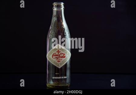 Santa Maria / RS / Brasilien. 03/24/2021. Gedenkflasche und leere Sodaflasche auf schwarzem Hintergrund. Kühlen von Ampullen. Kohlensäurehaltige Getränke Alte Coca-Cola-Kontra Stockfoto