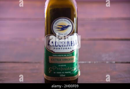 Olivenölflasche auf Holzhintergrund. Speiseöl. Verpackung zur Lagerung von Pflanzenöl. Produkt, das zum würzen von Lebensmitteln und Salaten verwendet wird. Stockfoto