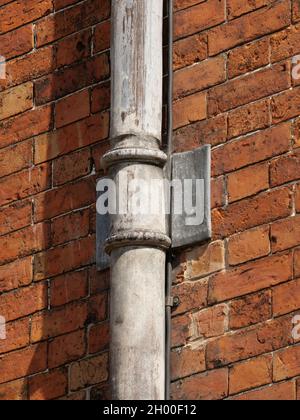 Eine Nahaufnahme einer Röhre an der Ziegelwand eines Gebäudes Stockfoto