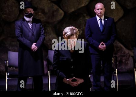 Jerusalem, Israel. Oktober 2021. (L-R) Rabbi Yisrael Meir Lau, Oberrabbiner von Tel Aviv und Vorsitzender von Yad Vashem, Bundeskanzlerin Angela Merkel und der israelische Premierminister Naftali Bennett stehen während einer Zeremonie im Holocaust-Gedenkmuseum von Yad Vashem in der Gedenkhalle. Quelle: Ilia Yefimovich/dpa/Alamy Live News Stockfoto