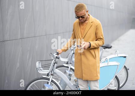 Mann mit Smartphone-App zum Fahrradverleih Stockfoto